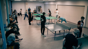 Młodzież gra na małej sali gimnastycznej w tenisa stołowego