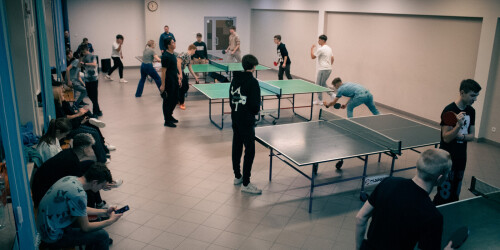 Młodzież gra na małej sali gimnastycznej w tenisa stołowego