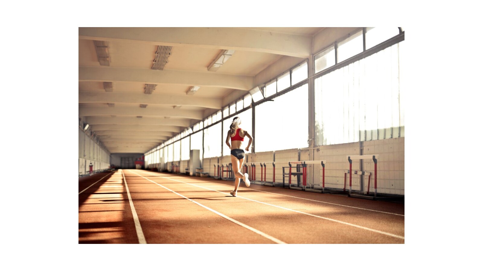 Kobieta biegnie w hali lekkoatletycznej